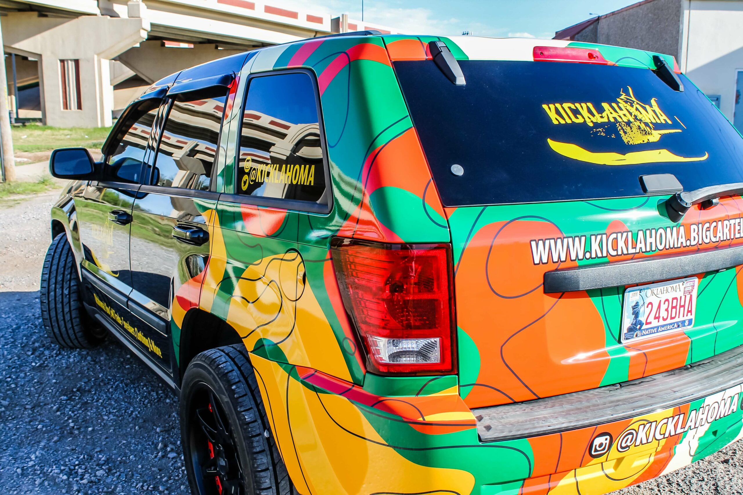 Side view of colorful Kicklahoma vinyl car wrapped at outdoors